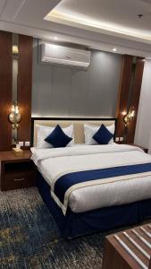 a bedroom with a large bed with blue pillows at شقق جوانة in Riyadh