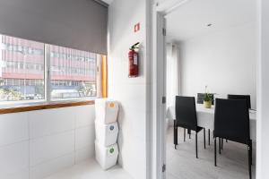 a room with a table and chairs and a fire extinguisher at Casa Trindade in Porto