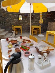 a table with food on a white table cloth at SARI KEÇİ TAŞ OTEL in Gokceada Town