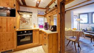 eine Küche mit Holzschränken und ein Wohnzimmer in der Unterkunft Remparts de Riquewihr - Le Petit Loup in Riquewihr