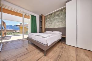 ein Schlafzimmer mit einem Bett und einem großen Fenster in der Unterkunft Hotel Catullo in Malcesine