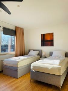 two twin beds in a room with a window at Messe Apartment am Rhein in Cologne