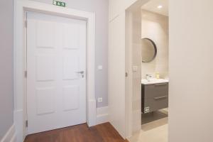 La salle de bains est pourvue d'un lavabo et d'une porte blanche. dans l'établissement Porto Almada 180 Apartments, à Porto 39 autres photos