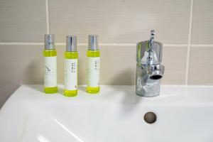 drei Flaschen ätherischer Öle auf einem Waschbecken in der Unterkunft Stylish Holiday Home Groups-Families 3M in London