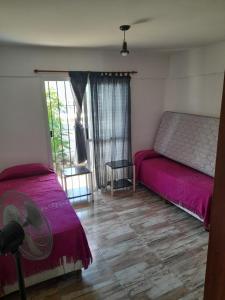 a bedroom with two beds and a window at El Chañar in Villa Carlos Paz +9 photos