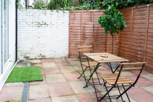 a patio with a table and chairs next to a fence at Stylish Holiday Home Groups-Families 3M in London