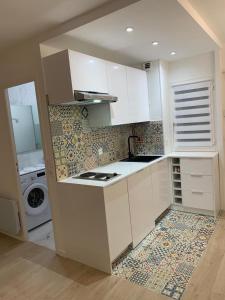 cocina con fregadero y lavadora en Studio en hypercentre refait à neuf avec une belle terrasse!, en Cabourg
