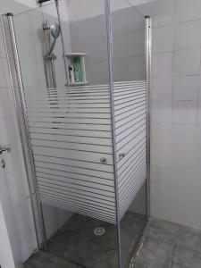 y baño con ducha y puerta de cristal. en Studio 91 By IsrApart en Ramat Gan