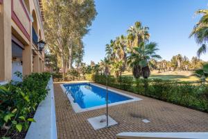 una piscina frente a un edificio con árboles en La Quinta II by Ĥ, en Isla Canela