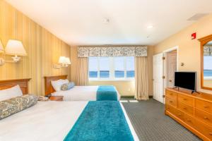 pokój hotelowy z 2 łóżkami i telewizorem w obiekcie Green Harbor Resort w mieście West Yarmouth