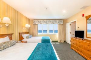 a hotel room with two beds and a television at Green Harbor Resort in West Yarmouth