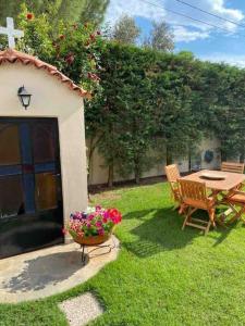 a garden with a table and chairs and a flower pot at Ερέτρια ~Ένας προορισμός μια ανάσα από την Αθήνα in Eretria