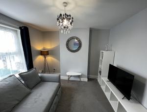 a living room with a couch and a television at Kema Cottage in East Cowes