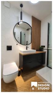 a bathroom with a white toilet and a mirror at APARTAMENT ODRODZENIA 14 in Szczytno