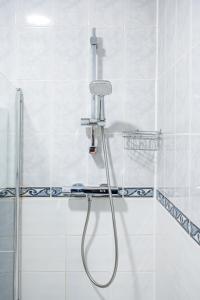 a shower with a hose in a bathroom at Modern Spacious Holiday Home 75 in London