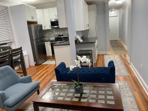 a living room with a blue couch and a kitchen at Spacious Apartment in Boston in Boston