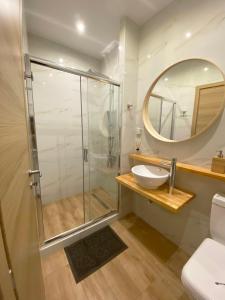 a bathroom with a shower and a sink and a mirror at Flight Apartments Airport by Airstay in Spáta