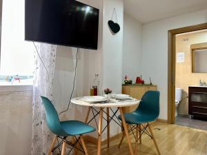 a dining room with a table and chairs and a tv at Apartamento en Santiago Bernabéu in Madrid