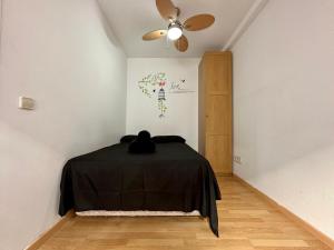 Zimmer mit einem schwarzen Tisch und einem Deckenventilator. in der Unterkunft Apartamento en Santiago Bernabéu in Madrid