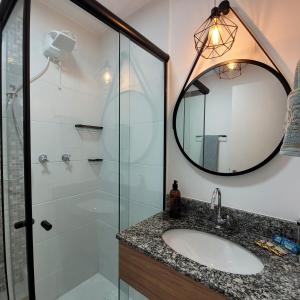 y baño con lavabo y ducha con espejo. en Studio Brás Com Piscina, en São Paulo