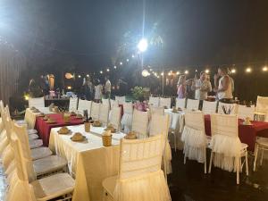 a group of tables and chairs with people in the background at Tam Coc Sky Bungalow in Ninh Binh