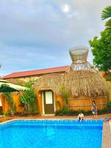 two children standing near a swimming pool in front of a house at Tam Coc Sky Bungalow in Ninh Binh