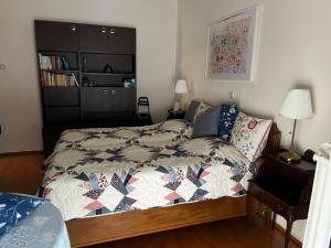 sypialnia z łóżkiem z kołdrą w obiekcie Spacious and sunny appartment in Cholargos w Atenach