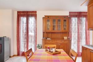 een keuken met een tafel en een houten kast bij Casa Vacanze Gilda in Chiesa in Valmalenco