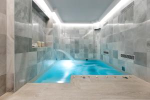- Baño con piscina y bañera azul en Seda Club Hotel - Small Luxury Hotels, en Granada
