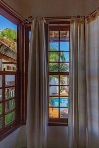 ventana en una habitación con vistas a la piscina en Pousada Laguna Blue, en Paraty