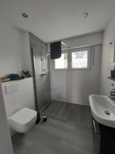 a white bathroom with a toilet and a sink at Kleine Auszeit in Bornheim