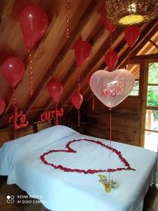 a bed with a heart and balloons on it at Finca Colibrí Zafiro, Altos del Rosario in Cali