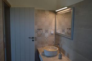 a bathroom with a sink and a mirror at Villa Rokanes Glass Stone with Pool in Kouvéllai