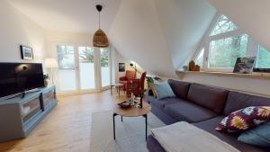 uma sala de estar com um sofá e uma televisão em Löningen - Ferienwohnung Hasestraße em Löningen