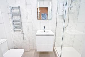 ein weißes Bad mit einem Waschbecken und einer Dusche in der Unterkunft Eldon Chambers Pod 7 by City Living London in London