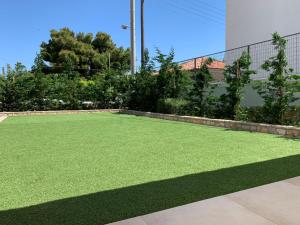 a yard of green grass in front of a building at Flight Apartments Airport by Airstay in Spáta