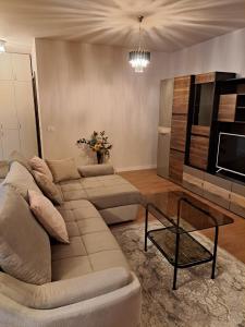 a living room with a couch and a table at Monica City Apartament in Timişoara