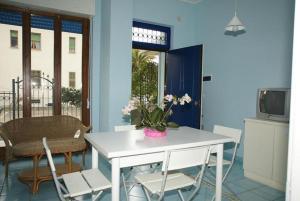 アルバ・アドリアティカにあるAppartamenti Alba Adriatica Viale Mazziniの白いテーブルと椅子、花瓶