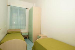 アルバ・アドリアティカにあるAppartamenti Alba Adriatica Viale Mazziniのベッド2台と窓が備わる小さな客室です。