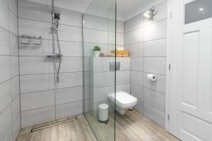 a bathroom with a toilet and a glass shower at Chalet Ester - Luxury Provençal House in Orava in Námestovo