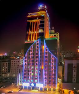 a tall building with lights on it at night at Frsan Palace Hotel in Manama