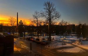 a parking lot with cars and a truck at sunset at Tammer Huoneistot - City Suite 2 - City View & Perfect location in Tampere