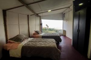 2 camas en una habitación con ventana grande en Bio Casa Colibrí, en Bogotá