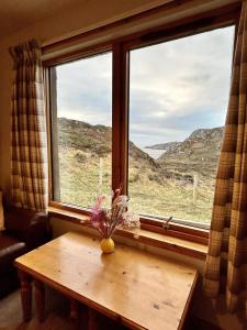 a table in front of a window with a view at Myrtle Cottage in Lairg