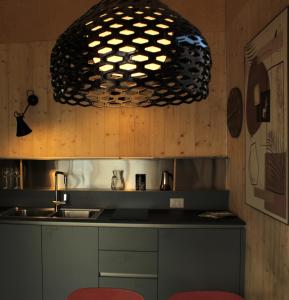 a kitchen with a sink and a pendant light at Maison 4 petite Casa design nel parco naturale in Crodo