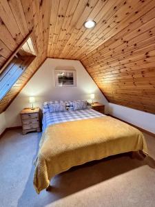 a bedroom with a large bed in a attic at Myrtle Cottage in Lairg