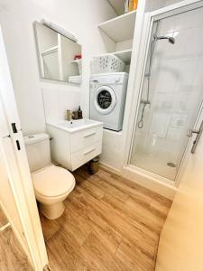 een badkamer met een toilet en een wasmachine bij Charme, balcon, parking, piscine, tramway, Netflix in Mérignac