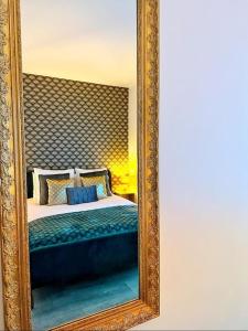 a mirror reflecting a bed in a bedroom at Charme, balcon, parking, piscine, tramway, Netflix in Mérignac