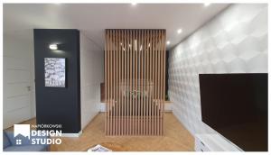 a lobby with a wooden divider in a room at APARTAMENT ODRODZENIA 14 in Szczytno