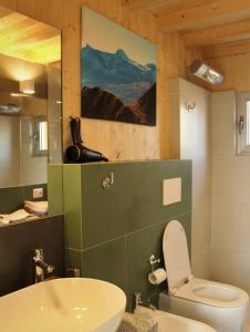 La salle de bains est pourvue de toilettes blanches et d'un lavabo. dans l'établissement Maison 4 petite Casa design nel parco naturale, à Crodo